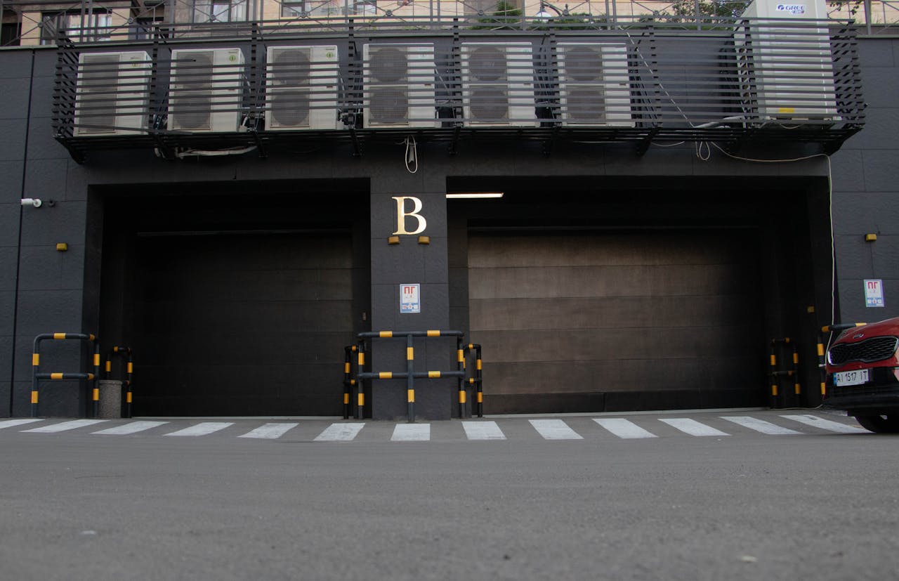 Modern garage entrance with air conditioning units above and a zebra crossing in Kyiv, Ukraine.